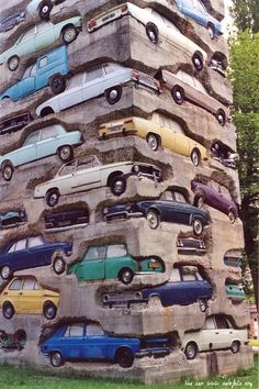 a bunch of cars stacked on top of each other in the shape of a pyramid