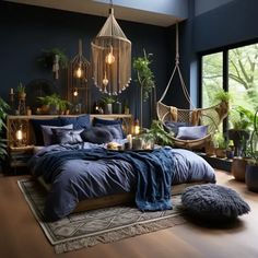 a bedroom with dark blue walls and wooden flooring is furnished with hanging chairs, plants, and a hammock bed