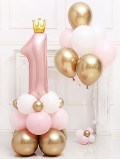 a pink and gold number one balloon arrangement