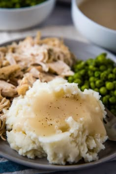 a plate with mashed potatoes, meat and peas