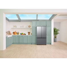 an empty kitchen with green cabinets and wood flooring is shown in this image, there are no people or objects on the counter