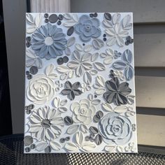 a close up of a piece of art made out of paper with flowers on it