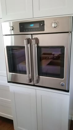 a stainless steel double oven in a white kitchen