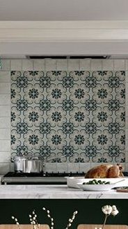 a kitchen with green cabinets and white tile backsplash, an island counter topped with flowers