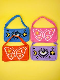 three crocheted purses are sitting next to each other on a yellow surface