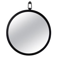 a round mirror hanging on the wall with a black frame and metal ring around it