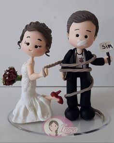 a wedding cake topper with a bride and groom tied up