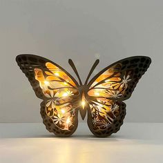 a butterfly shaped light with lights on it's wings is sitting on a table