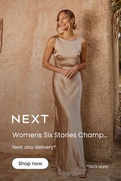 a woman standing next to a wall wearing a dress with the words next women's six stories champ