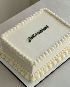 a white square cake with the words just married on it