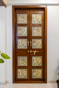 a wooden door with decorative glass panels on the front and side doors, along with a potted plant