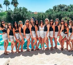 a group of women standing next to each other near a pool