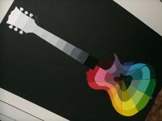 an image of a colorful guitar on the back of a laptop computer screen that has been cut out