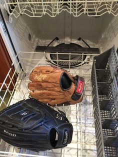 two baseball gloves and a catchers mitt in a dishwasher