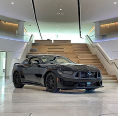 a black sports car parked in front of some stairs