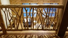 a wooden railing made out of branches in front of a window