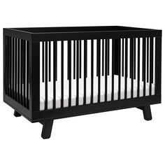 a black crib with white sheets on the bottom, and two wooden legs in front