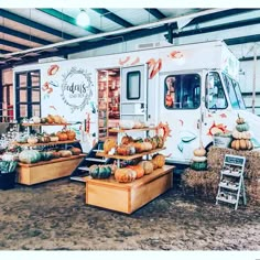 the food truck has pumpkins and hay in front of it