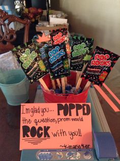 some candy sticks are in a bucket on a table with a sign that says i'm glad you the question from would rock with you