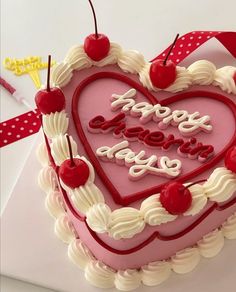 a heart shaped cake with the words happy new year written on it and cherries