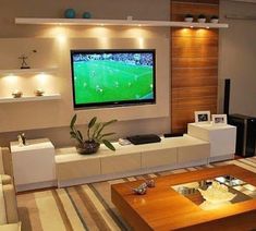 a living room filled with furniture and a flat screen tv mounted to the side of a wall