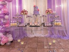 a table topped with lots of cake and balloons