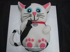 a white cat cake with blue eyes and pink paws on it's back legs