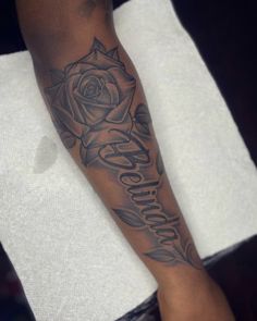 a person with a rose on their arm and the word love is written in cursive writing