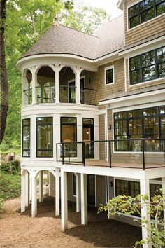 a large white house with lots of windows on it's sides and an attached deck