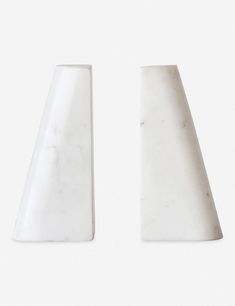 two white marble vases sitting next to each other on a white surface with no one in the photo