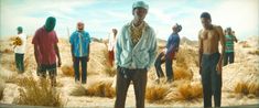 a group of men standing around each other in the desert