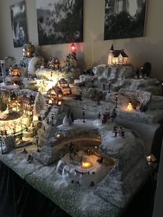 a christmas village with lights and snow on the ground