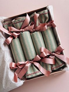 an open box filled with pink ribbon wrapped presents