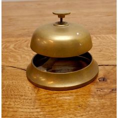 a brass colored object sitting on top of a wooden table