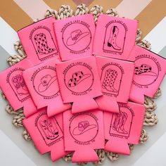 pink stickers with different designs on them sitting in a basket next to a wall