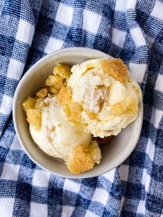 a bowl filled with ice cream on top of a blue and white checkered cloth