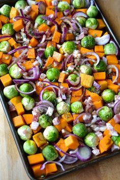 a pan filled with vegetables on top of a wooden table