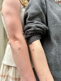 two people with tattoos on their arms