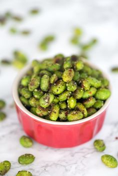 a red bowl filled with brussel sprouts on top of a table