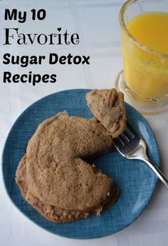 a blue plate topped with cookies next to a glass of orange juice and a fork