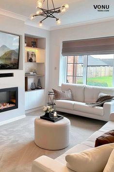 a living room filled with furniture and a fire place in front of a large window