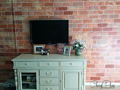 an entertainment center in front of a brick wall