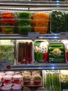 fresh vegetables are displayed in plastic containers on display at a grocery store's deli