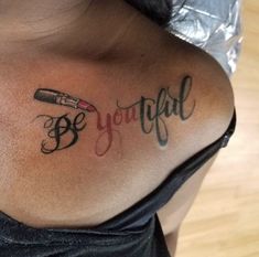 a woman with a tattoo on her back that says be joyful next to a pen