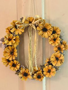 a wreath with yellow flowers hanging on the front door