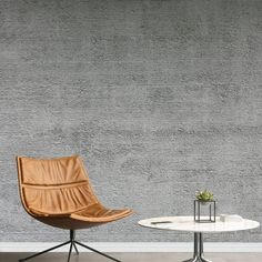 two chairs and a table in front of a wall with grey textured paper on it