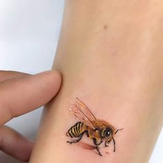 a small tattoo of a bee on the wrist