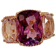 Elegant 18kt Rose Gold Three Stone Ring with Rope Twist Border with split shank detail. The ring features a faceted cushion cut Deep Amethyst Center stone and two Pale cushion cut Amethyst side stones stones surrounded by twisted gold rope. The center Amethyst stone measures ~5/8" tall (including the rope boarder) and ~1/2" wide (including the rope border). The two pale Amethyst side stones measures ~1/2" tall (including the rope border) 3/4"across (including the rope border). The ring measure ~ Rope Border, Dream Rings, Gold Amethyst Ring, Rope Twist, Amethyst Gold, Three Stone Ring, Pink Topaz, Split Shank, Pretty Rings