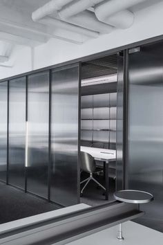 an office cubicle with sliding glass doors and a desk