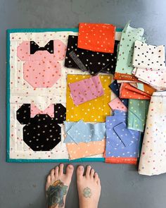 a person with their feet on the ground next to many different pieces of cloths